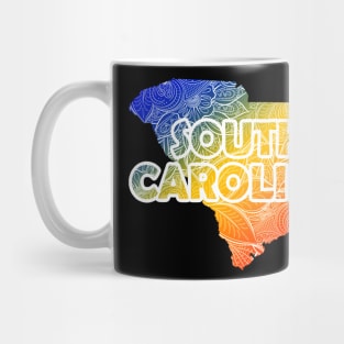 Colorful mandala art map of South Carolina with text in blue, yellow, and red Mug